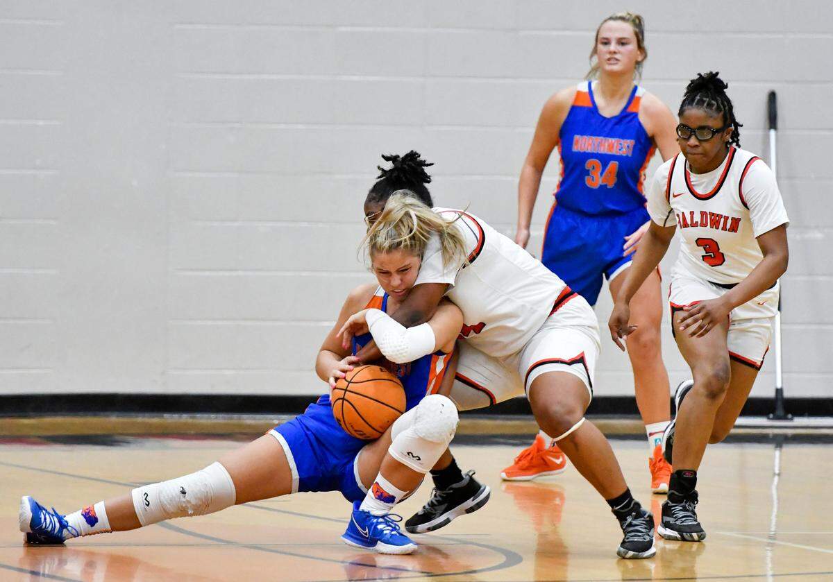 Baldwin’s Morgan Ruff (34) and Northwest Whitfield’s Emma Allen (11) battle for a loose ball Tuesday night in their GHSA 4A quarterfinal. Baldwin won the game 57-46 and will play Luella in the semifinals at 2 p.m. Friday at Fort Valley State.