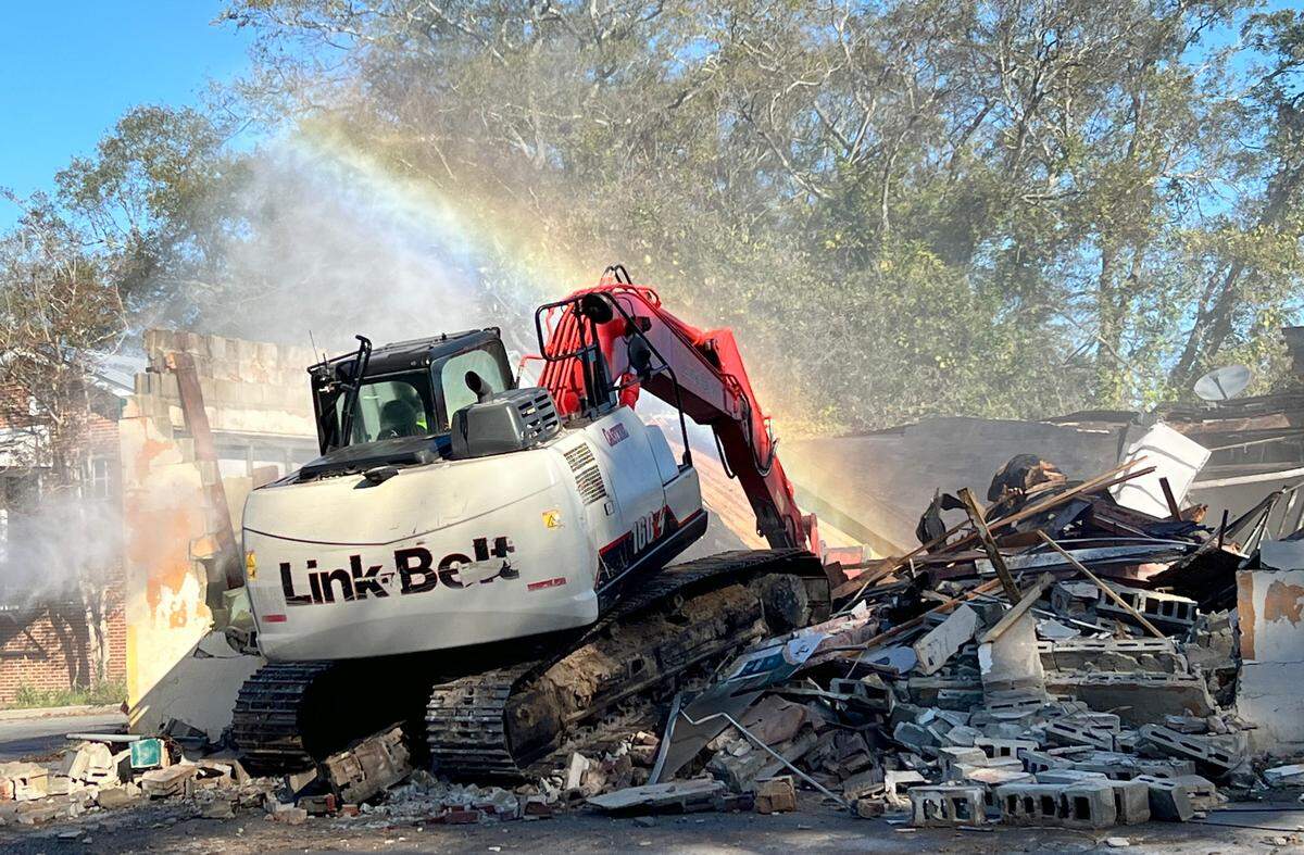 An excavator tears down the former Bateman and Wade Grocery at 2283 Clayton St. on Wednesday.