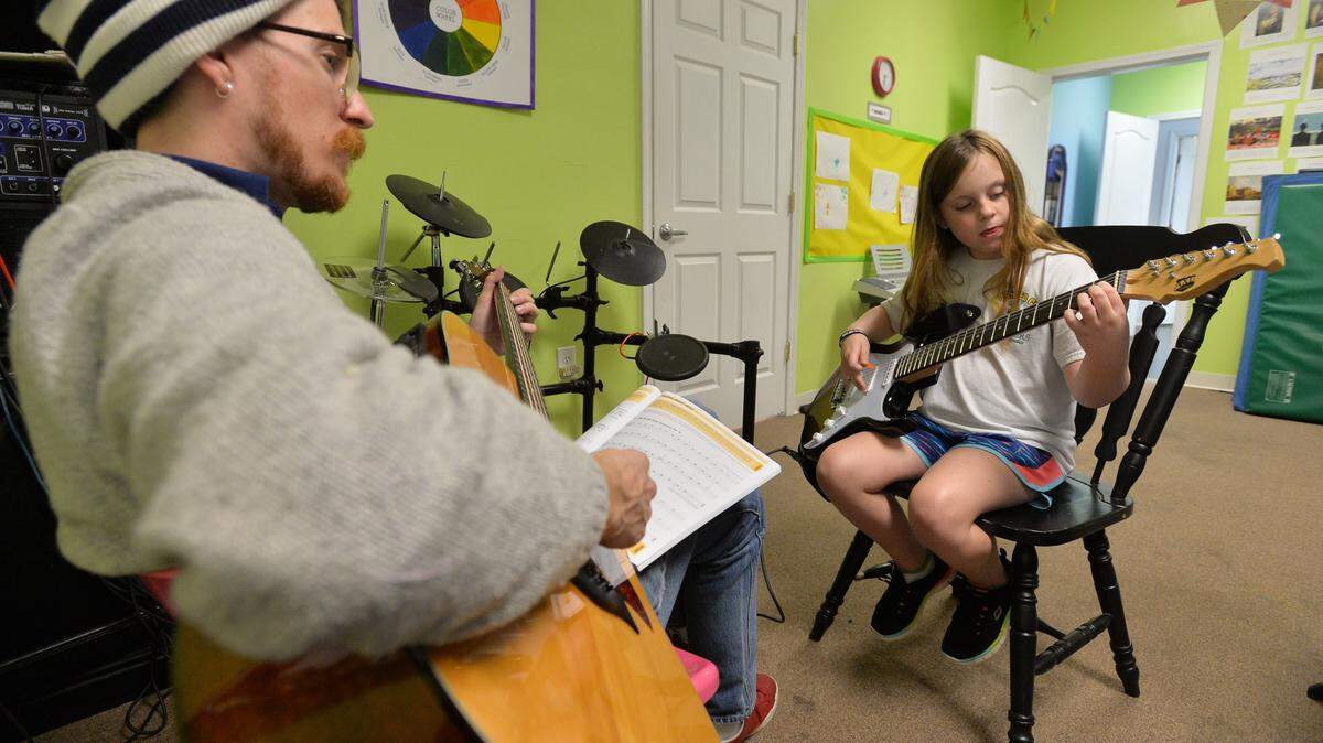 Peacock Performing Arts Center guitar instructor Danny Davis, left, teaches a class with Michaela Jones.