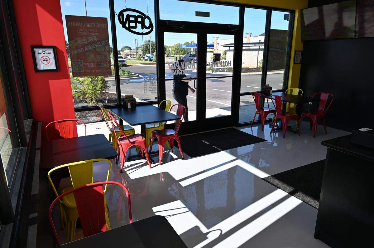 A small dine-in area at the front of Holy Pie! Pizzeria. The pizza restaurant offers dine-in, carry out, delivery, as well as a drive thru.