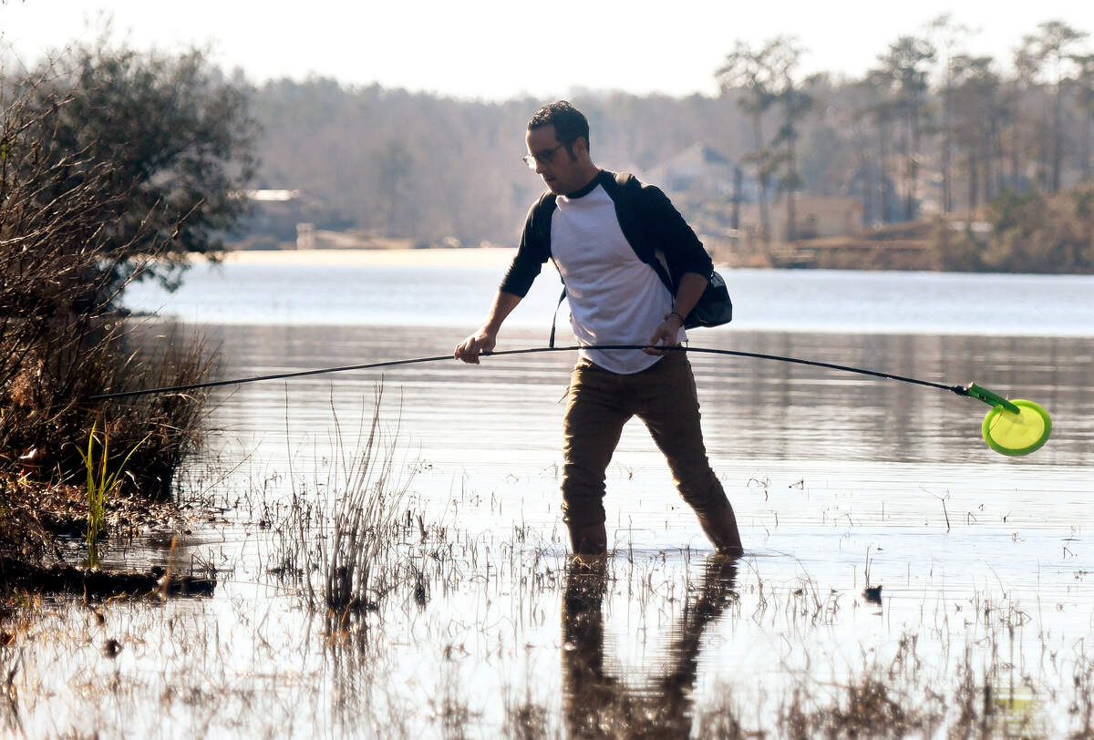 JASON VORHEES/THE TELEGRAPH Macon, GA, 01/09/2018: Charlie Smith uses a Disc Gator while wading into Lake Tobesofkee to retrieve his disc on the 15th hole at Claystone Park Tuesday afternoon. Smith playing a round of disc golf with his friends David King and Joel Smith. Although the air temperature reached the mid 60’s Tuesday afternoon Smith said the water was cold.