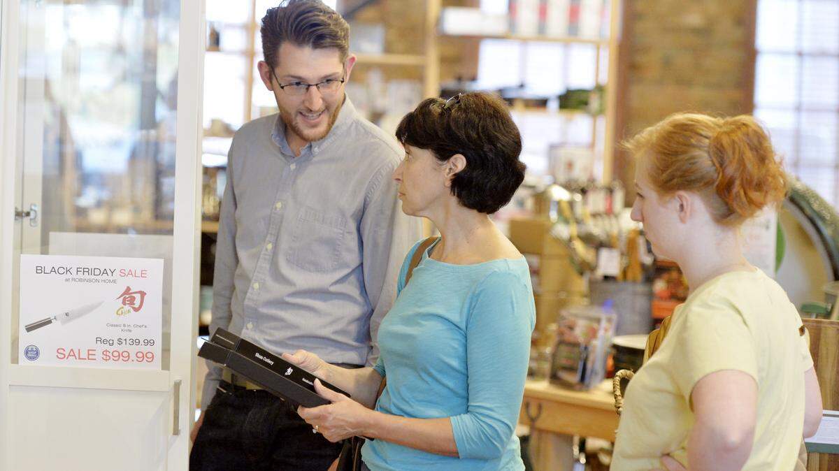 Owner Will Robinson helps Peggy Elliott and her stepdaughter Amber Schaller select cutting knives for Elliott at Robinson Home on 1st Street in Macon Saturday morning. The store was having sales while participating in Small Business Saturday.