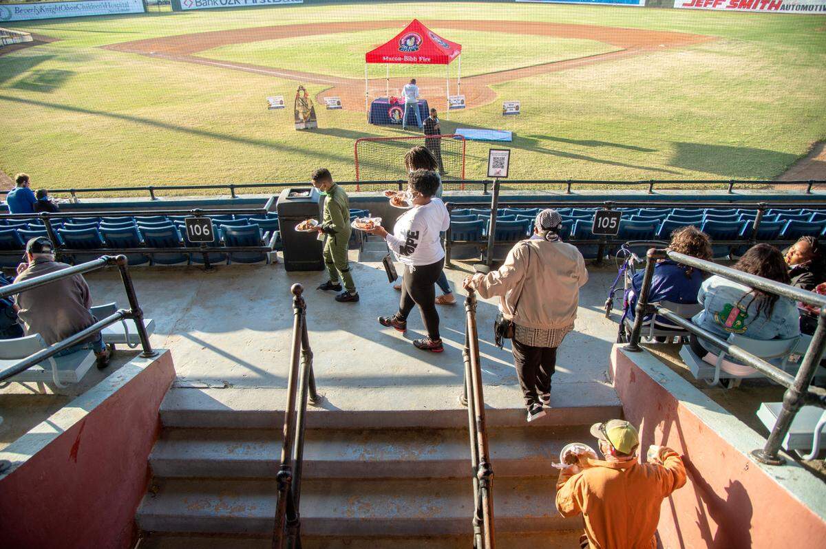 Visitors walk into Luther Williams Field with plates full of pancakes and bacon Saturday morning during the Cherry Blossom Festival Pink Pancake Breakfast.