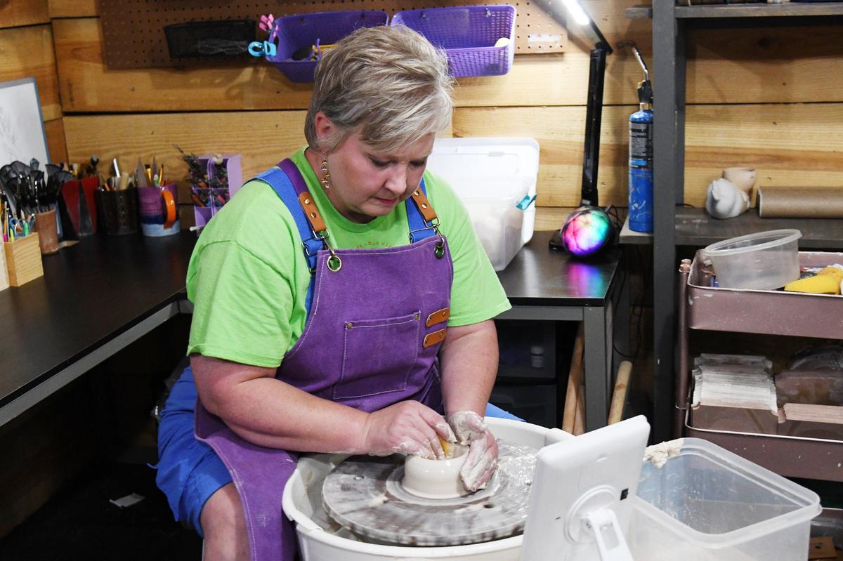 Goodjuju Pottery Studio owner Julie McGlamery works a lump of clay on a pottery wheel inside of Goodjuju Pottery on Tuesday, July 9, 2024, in Forsyth, Georgia. Goodjuju Pottery Studio opened in March and offers pottery making and painting classes in downtown Forsyth.