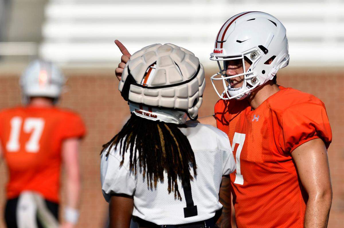 Mercer quarterback Carter Peevy (7) speaks with receiver Devron Harper (1) during a team practice August 15. The Bears open the season against N. Alabama in Montgomery August 26.
