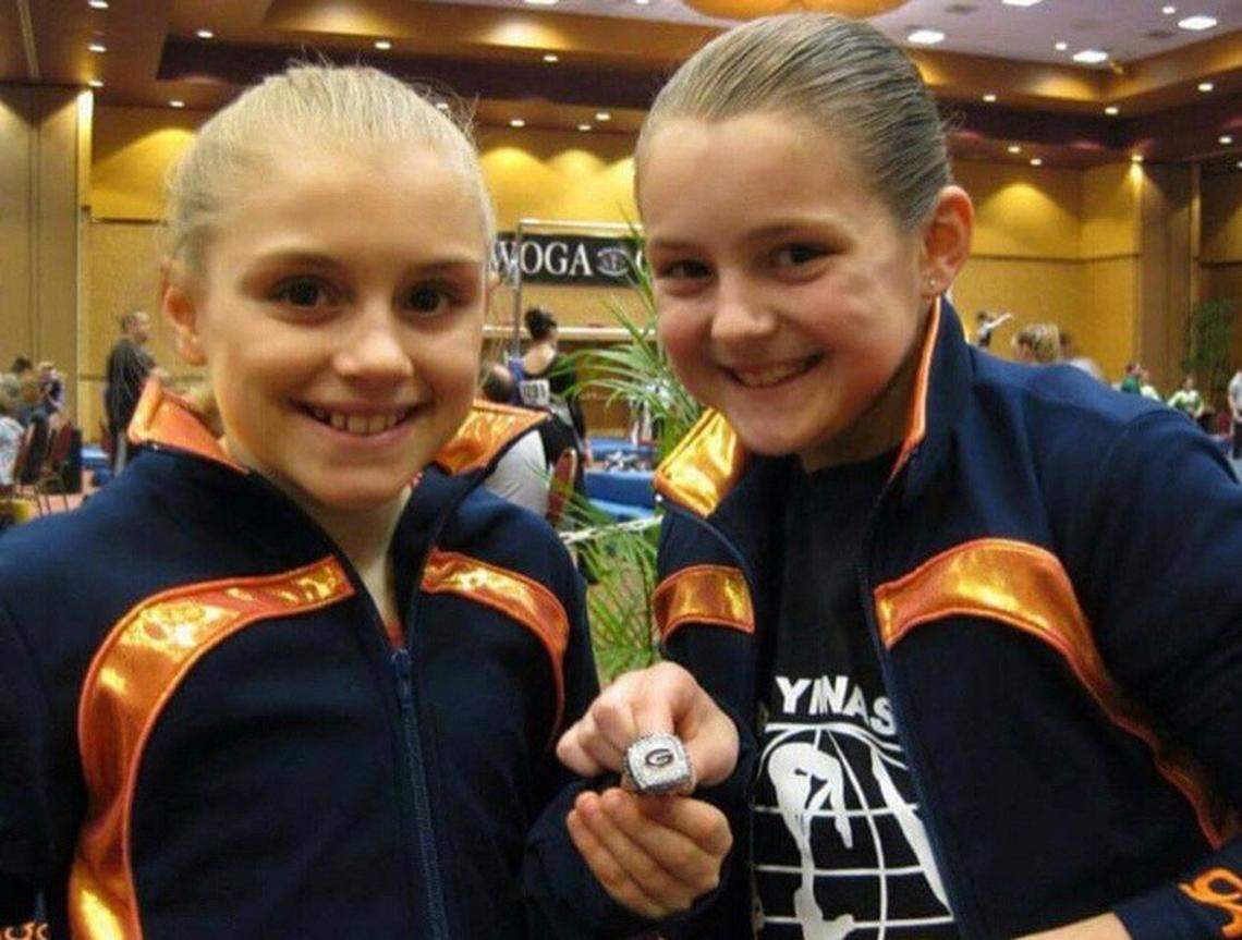 GymDogs Sami Davis and Rachael Lukacs hold a Georgia championship ring as fourth graders at a meet in Texas.
