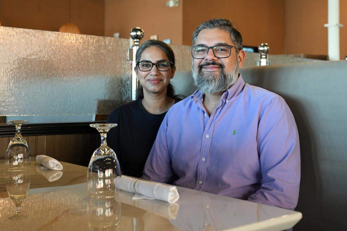 Owners Ishtpreet “Jay” Bhullar (right) and his wife Kirti Bhullar pose inside a booth at 7 Spices Authentic Indian Restaurant & Bar in Warner Robins. The couple purchased what was Curry Mantra in 2022 and renamed it 7 Spices in 2023.