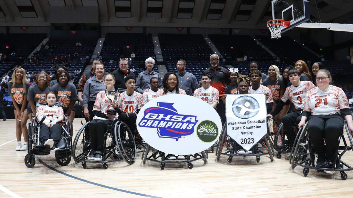 The Houston Shark basketball team poses with their cheerleading team and coaches for a group photo after they won their 10th AASCP state championship in 11 years.