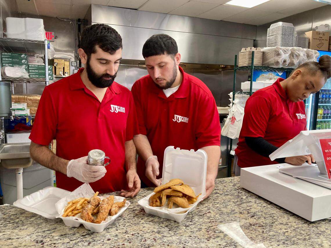 Hamza Awawdeh, left, salts a tilapia and wings combo and a chicken tenders combo at a JJ Fish & Chicken that just opened at 4351 Pio Nono Ave. in Macon. Awawdeh manages the new restaurant.