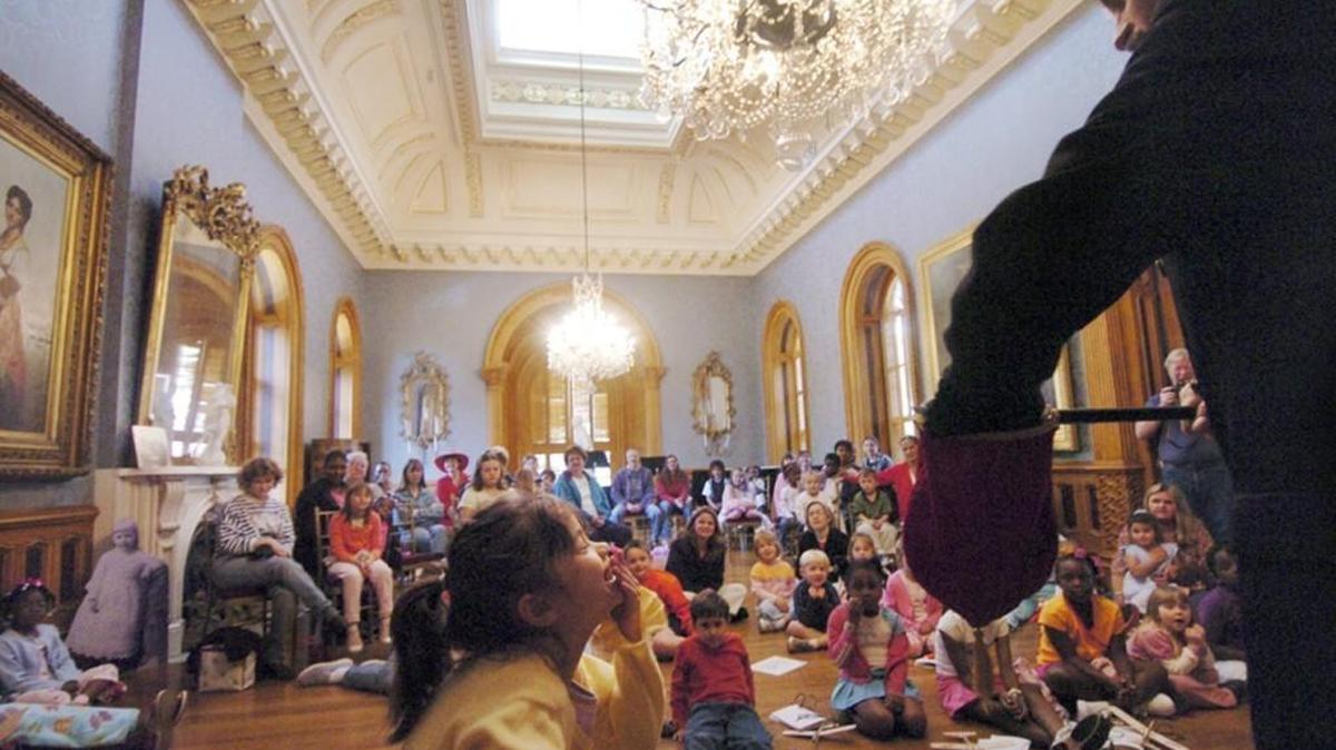 Hannah Williams, 5, giggles as she helps magician Mike Fuller perform in the music room of the Hay House in a previous Hay Day celebration.