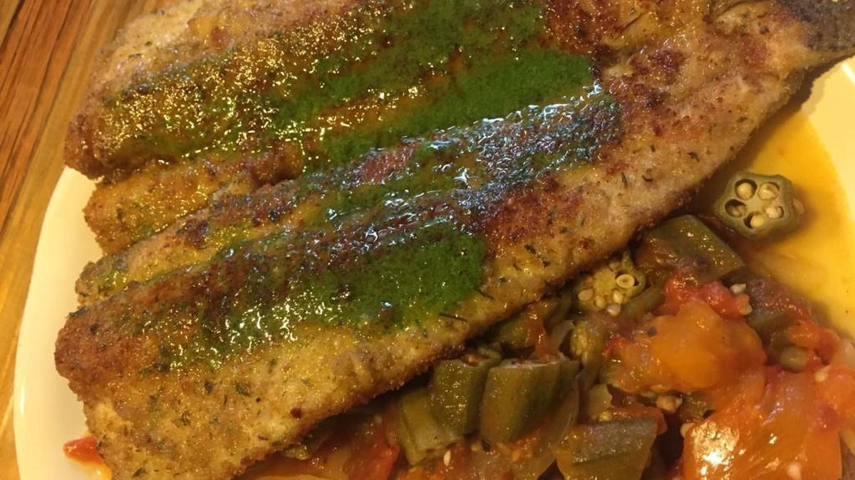 Parmesan-crusted trout is topped with pesto and served with okra and tomatoes.
