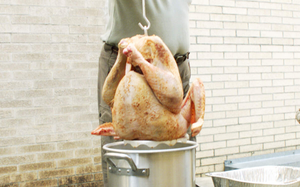 Telegraph editorial page editor Charles Richardson fries a turkey outside the newspaper's former office on Broadway in Macon.
