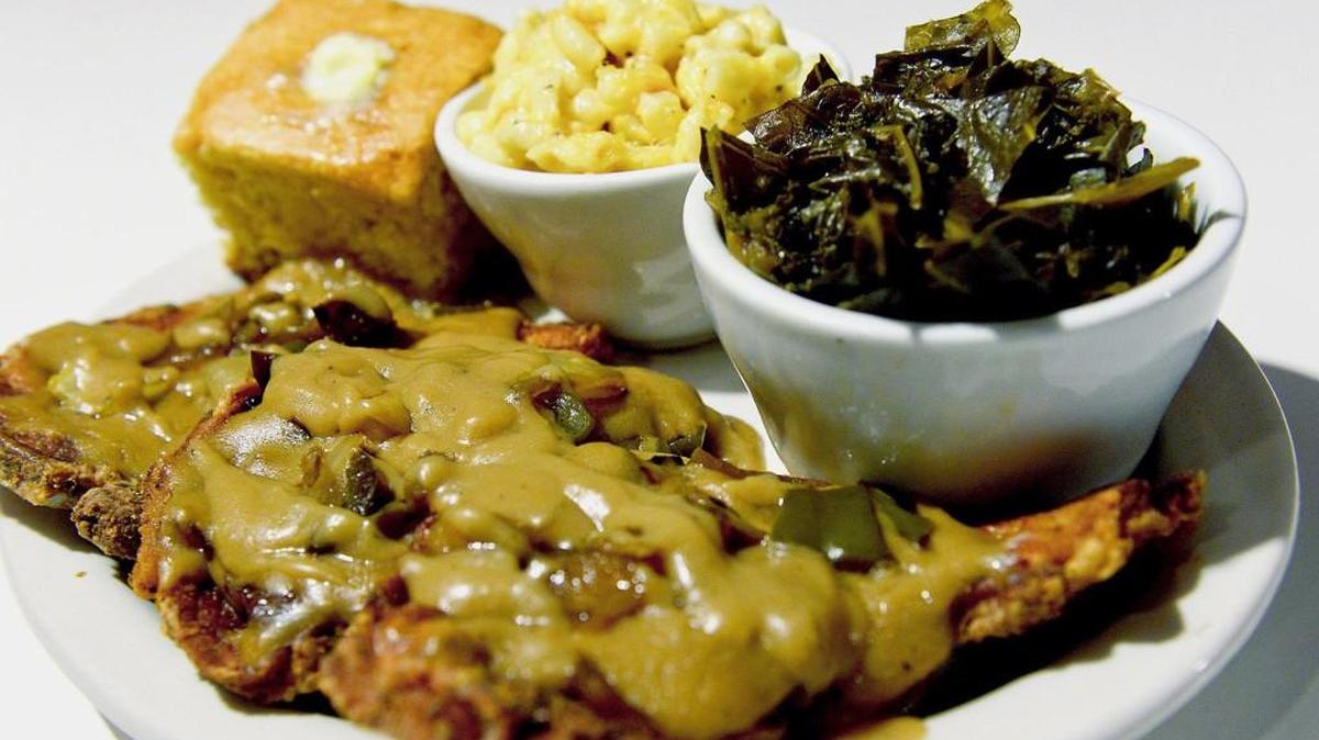 Carmi Soul Food Restaurant in Allegheny West serves smothered pork chops with sides of cornbread, macaroni and cheese and collard greens.