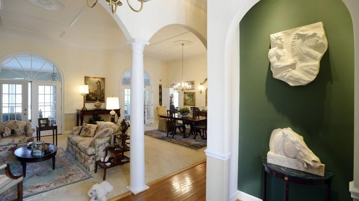 Instead of a coat closet, an arched niche in the foyer repeats the detail on both sides of the living space and is lighted to display more artifacts in JoAnna Watson’s collection.