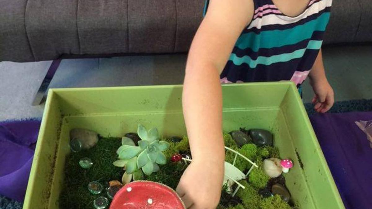 Mattie Wells of Virginia Beach, Virginia, works on her fairy garden, complete with a mini toadstool house, bridge, birdbath, pebbles and gems.
