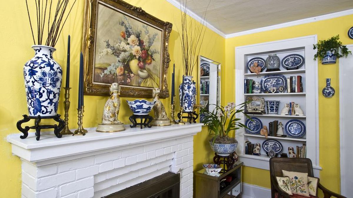 Carol Martin pairs her collection of blue and white porcelain with daisy yellow in the living room, complemented by hints of coral.