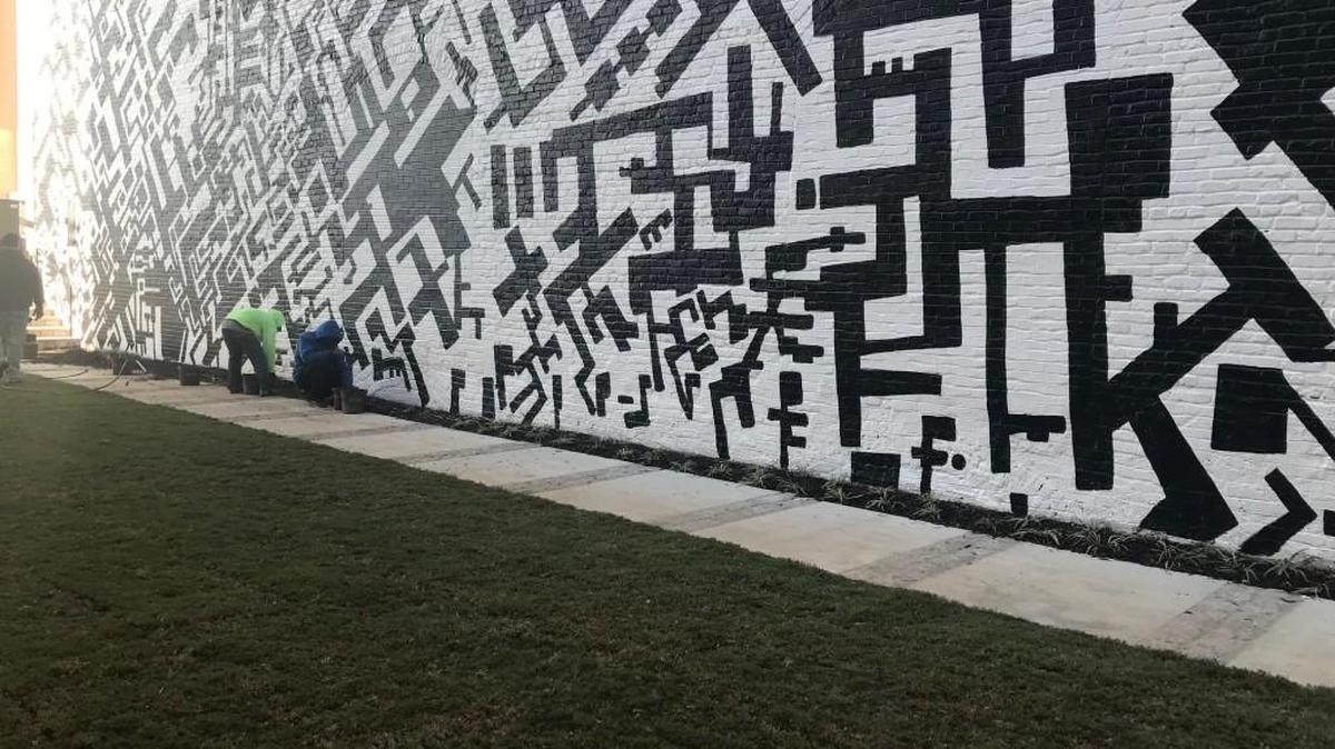 A mural thought gone has been re-created by the original artist with a little help from his friends and a lift from a mechanical friend not available two decades ago.