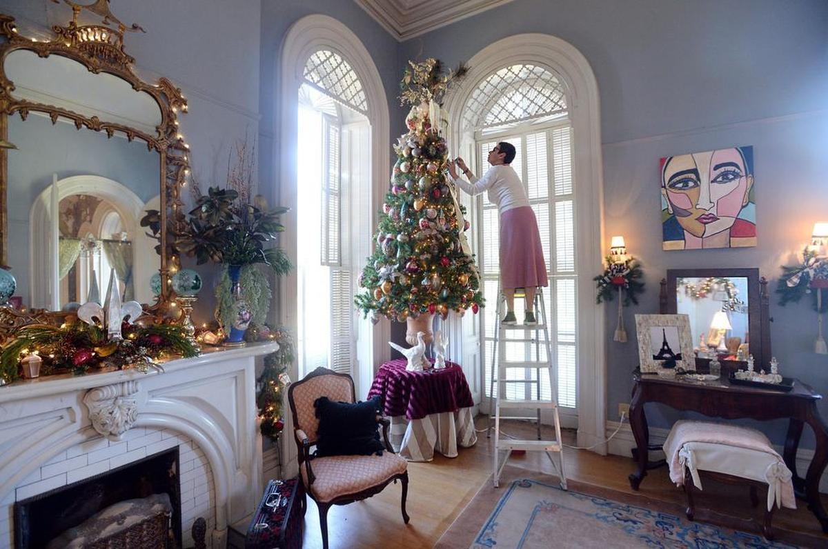 Priscilla Esser adds last ornaments to elevated tree in northwest bedroom.