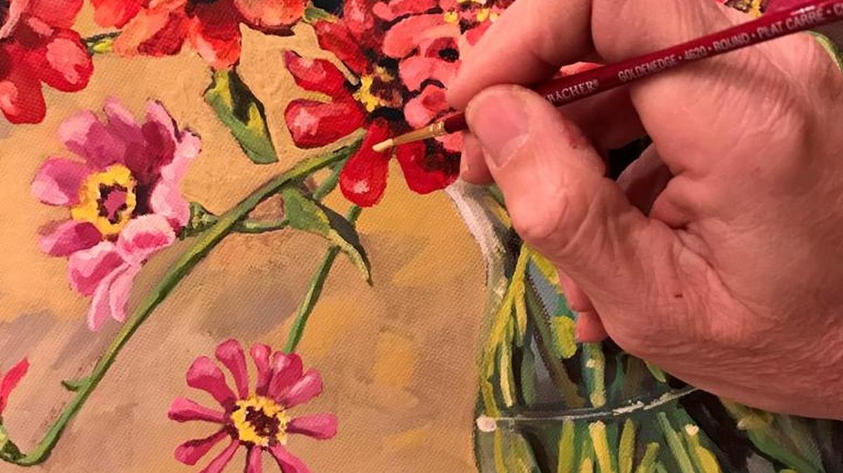 Mark Ballard add a final touch on his zinnia painting.