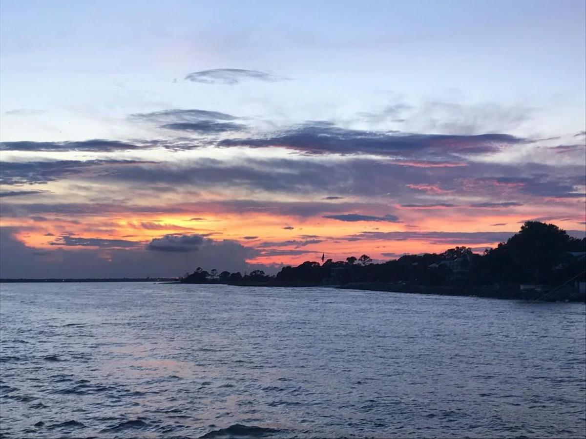 A view of sunset at St. Simons Island is seen from a pier.