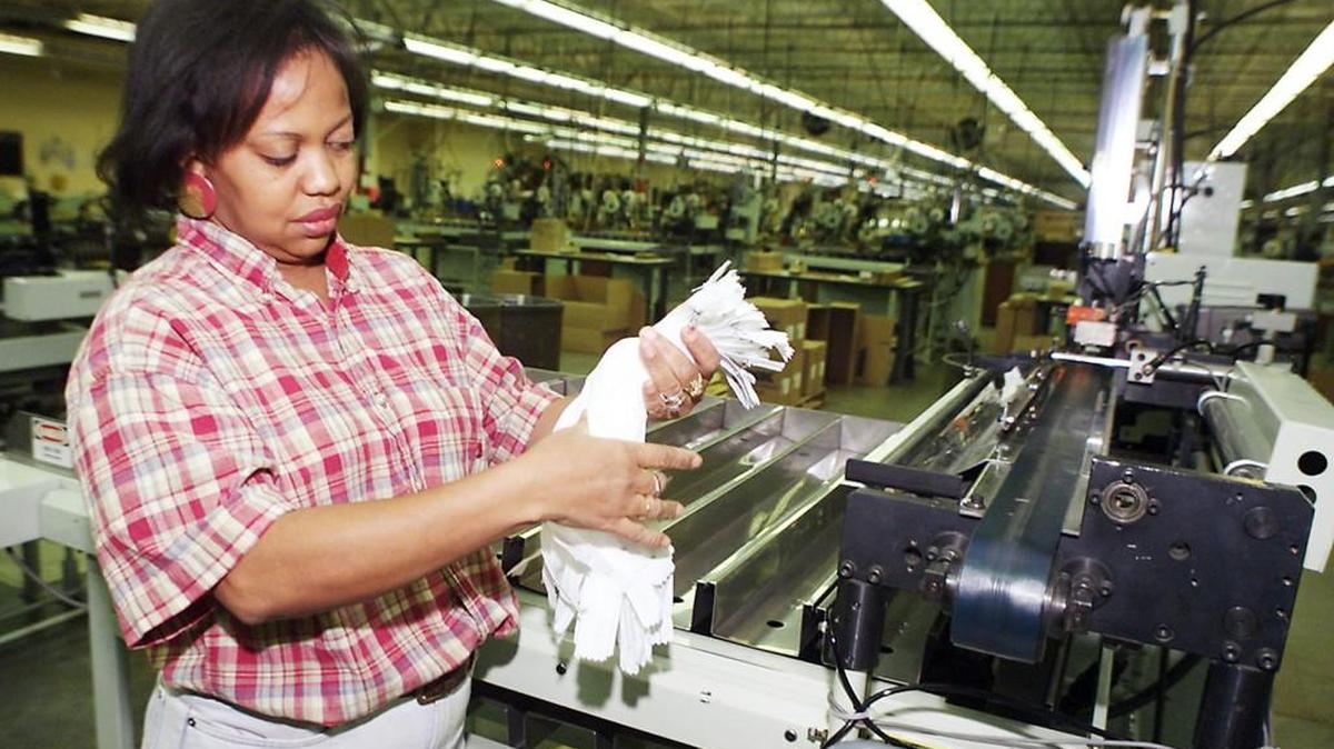 In 1999, YKK employee Peggie Curry inspects some of the 7 millon zippers that the company will produce in one day.