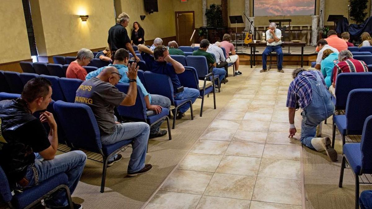 Members of South Walker Baptist Church, led by pastor Mark Carroll, pray Sunday at the conclusion of what is normally a time for Bible study, but which became a talk about experiences during the flood in Walker, Louisiana.