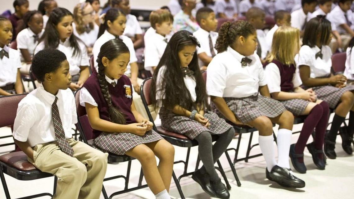 St. Peter Claver Catholic School students bow their heads during morning prayers Aug. 10.