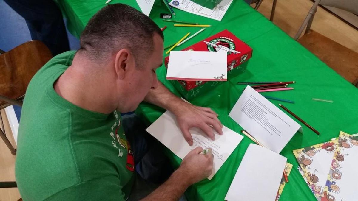 Matt Riggins writes a personal note to a child to be placed in an Operation Christmas Child gift box.