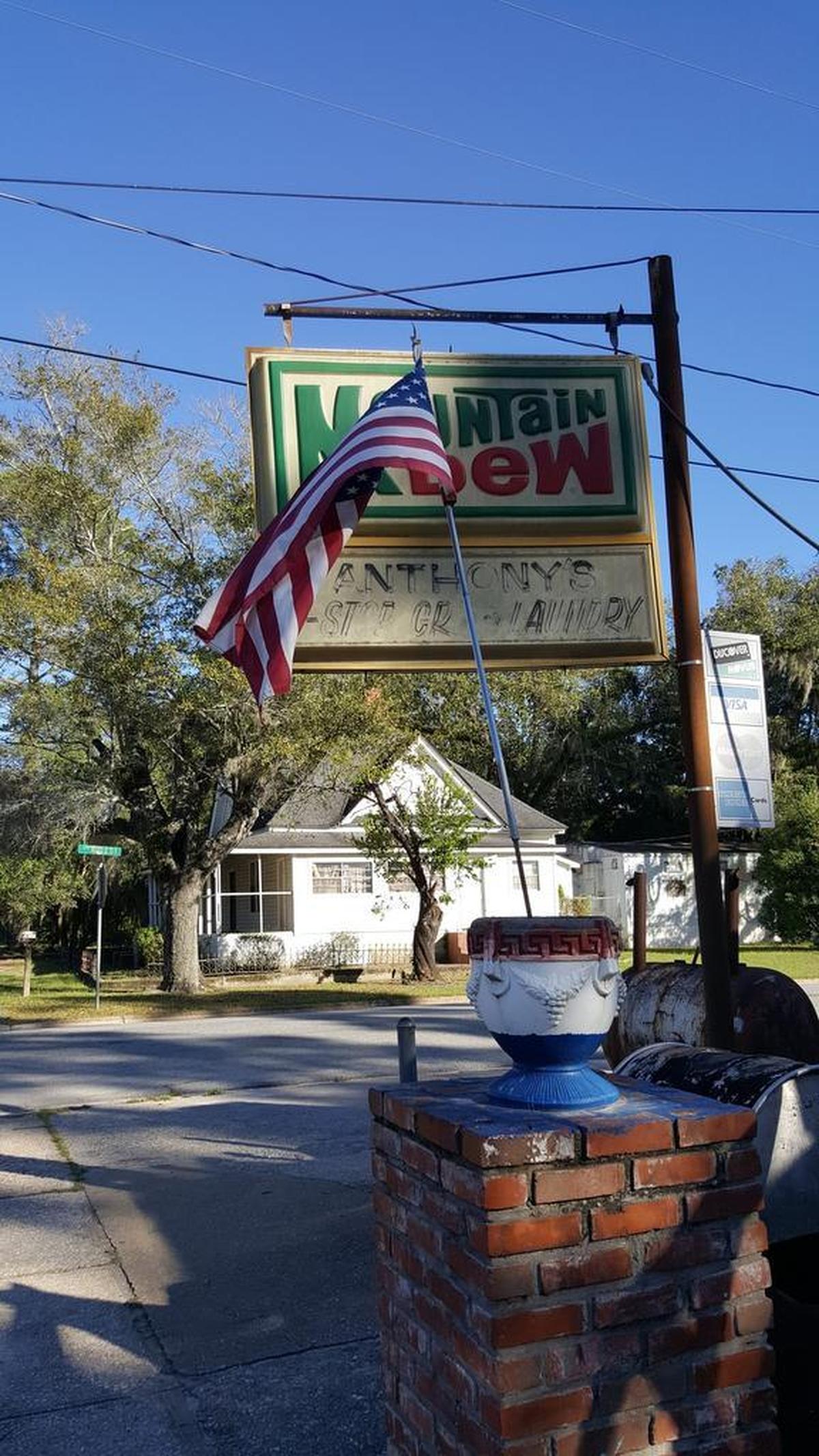 American flag stuck in a red, white and blue cement planter outside Anthony’s 1-Stop Grocery and Laundry.