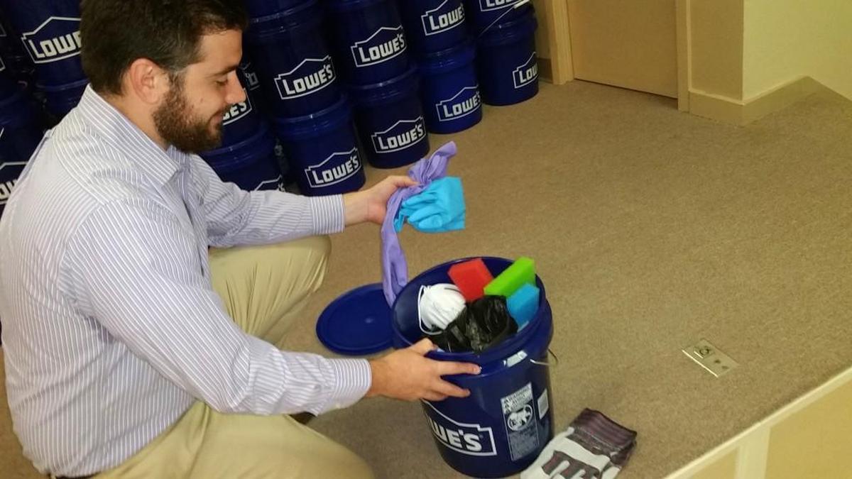 The Rev. Greg Harrison goes through a flood bucket of cleaning supplies and materials ready for delivery and use in hurricane damaged homes in Texas. Wesley United Methodist Church is a collection point for the UMC project.