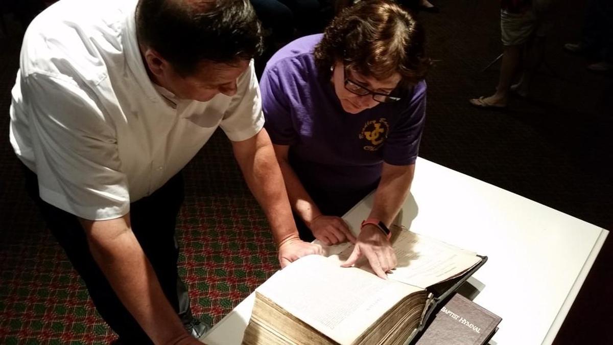 Steve Johnson and Jan Greene of Bradley Baptist Church look for dates in a Bible that has itself had a long history at the church.
