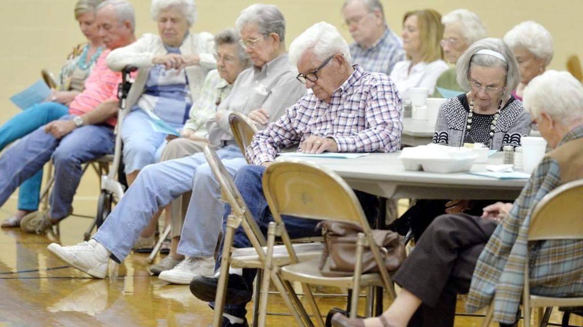 Church members bow their heads in prayer during Bible study Wednesday at Vineville Baptist Church.