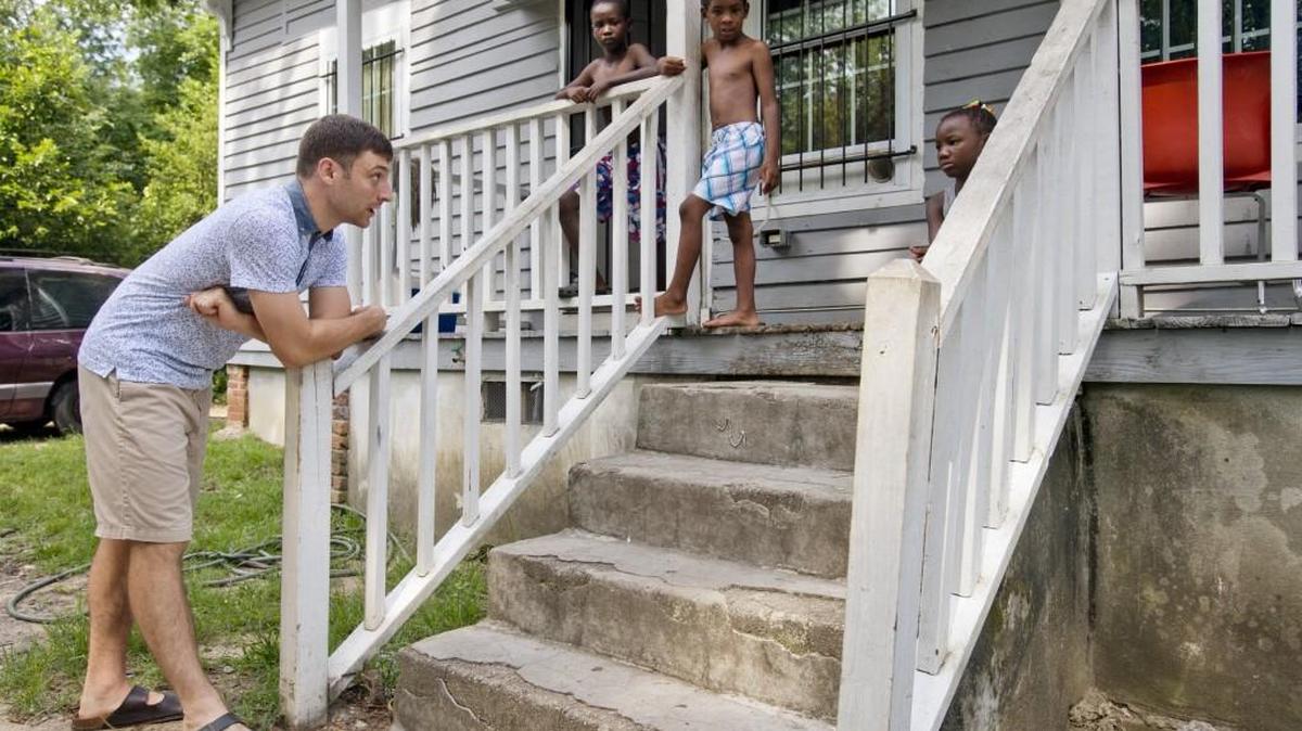 Strong Tower Fellowship member Andrew Berndt speaks with the children of church member Joyce Faison at their home along Holts Lane on July 9.