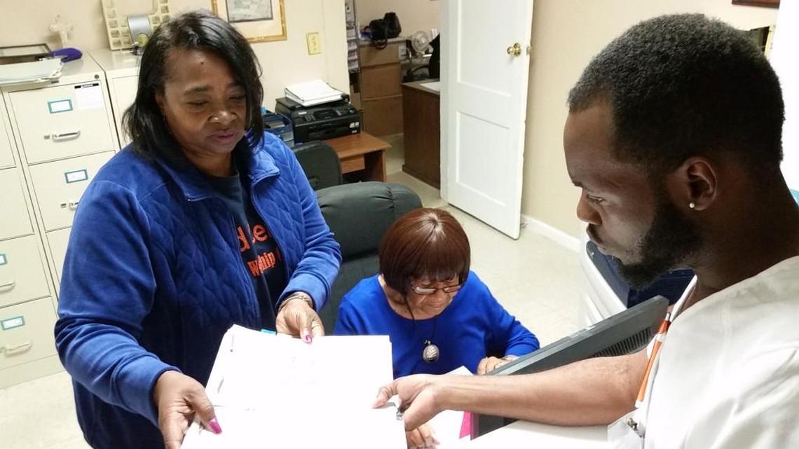 The Feed Center’s free medical clinic supervisor Maryann Ray checks paperwork with Shirley Rouse and Brandon Chatman, clerical and intake volunteers.