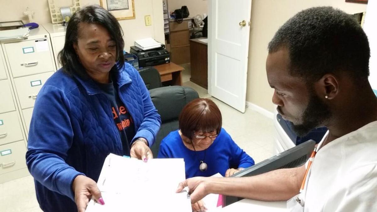 The Feed Center’s free medical clinic supervisor Maryann Ray checks paperwork with Shirley Rouse and Brandon Chatman, clerical and intake volunteers.