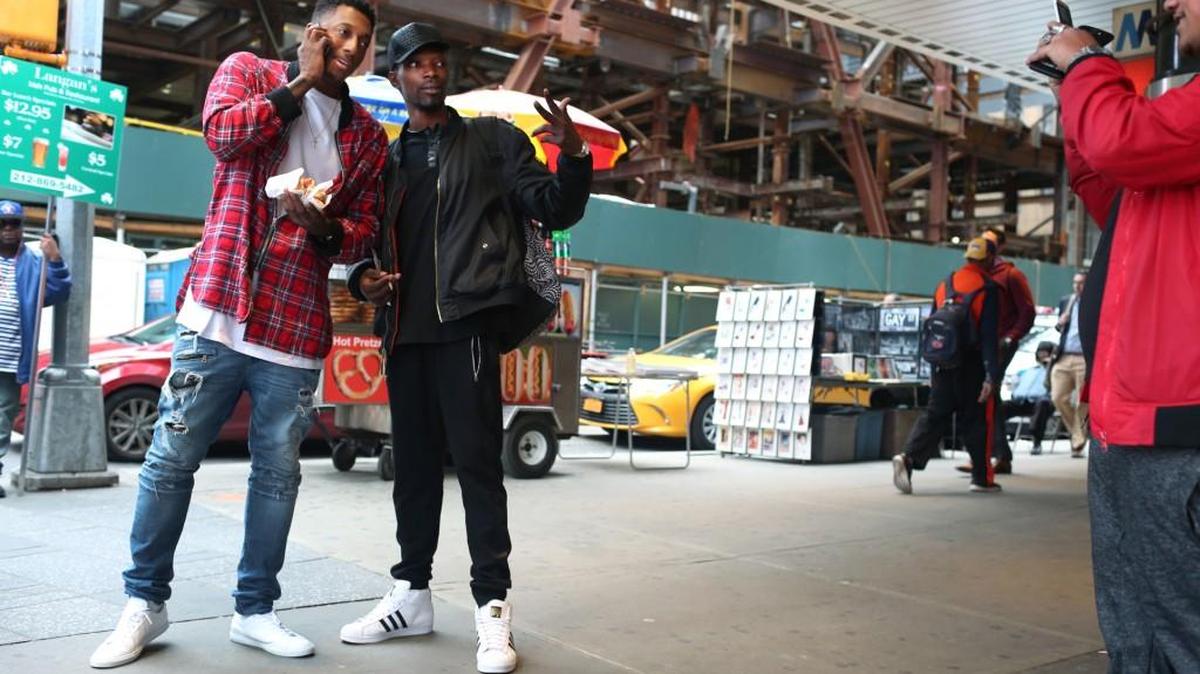 Lecrae, left, has his photograph made with a fan, Marcus “WK” Bryan, while getting hot dogs in New York’s Times Square.