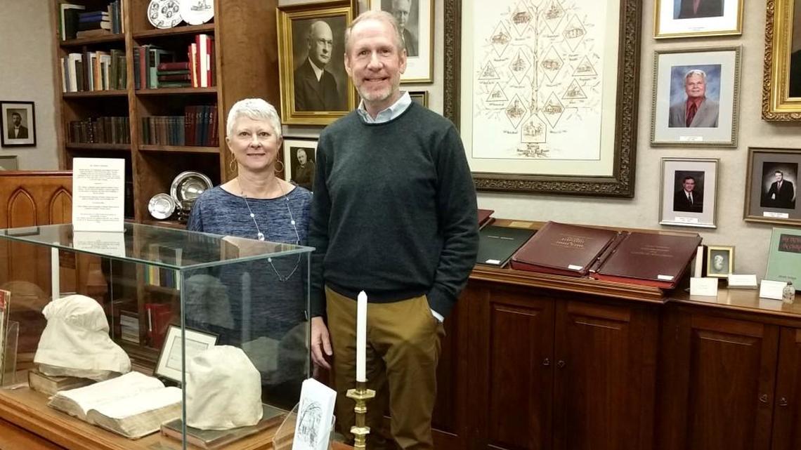 Debbie and Jimmy Towson stand in Mulberry Street UMC’s history room amid portraits of former pastors and historical church artifacts. Mulberry is known as the mother church of Georgia Methodism.