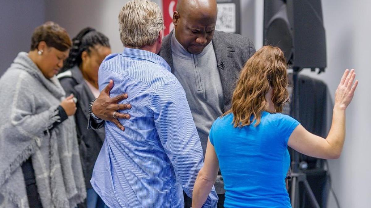 Pastor LaQuonne Holden joins others in prayer at CrossLife Church.