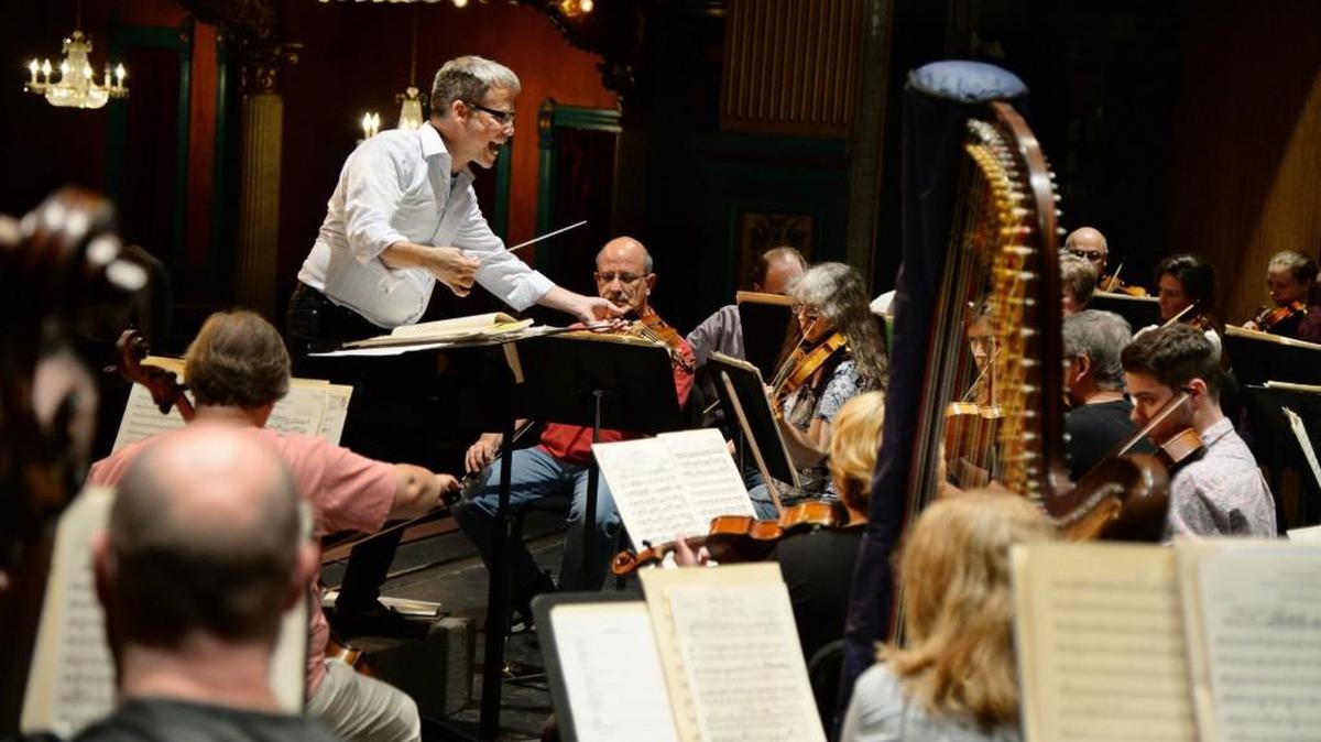Music director and conductor Gerald Steichen, left, coaxes the best from his violins as the Macon Symphony Orchestra rehearses for its final performance.