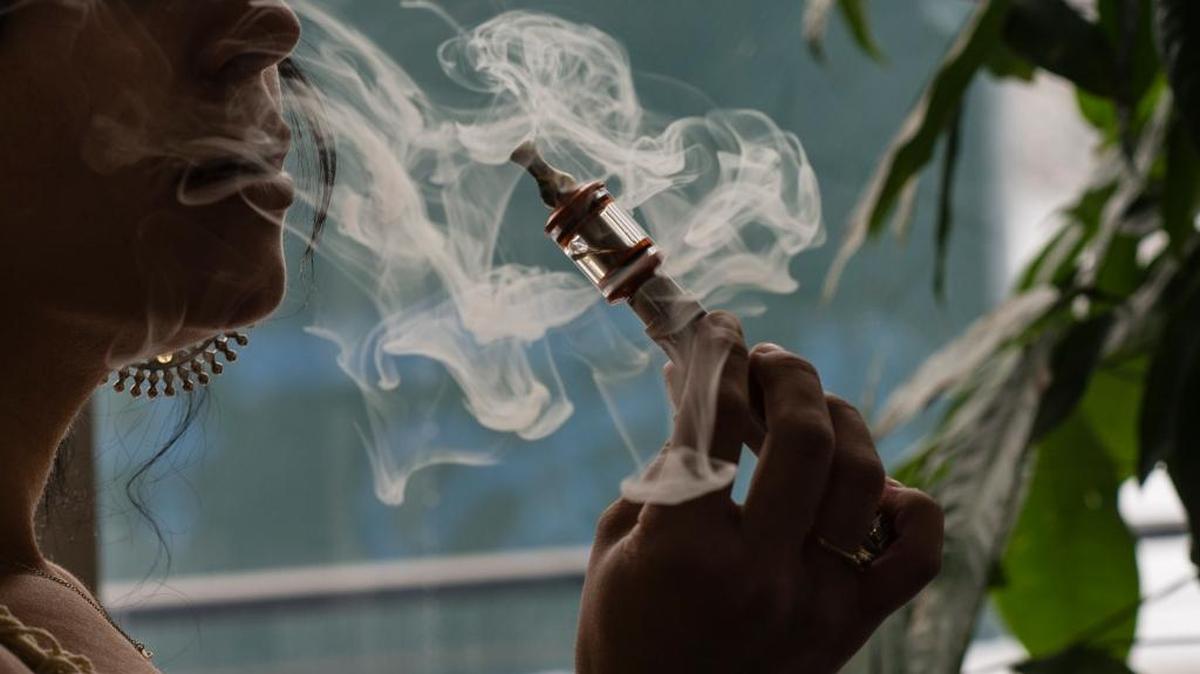A woman smokes from a vaping device.