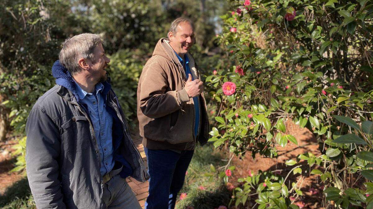 Matthew Israel, left, and William Khoury, share a laugh in the formal garden at the American Camellia Society headquarters at Massee Lane, south of Fort Valley