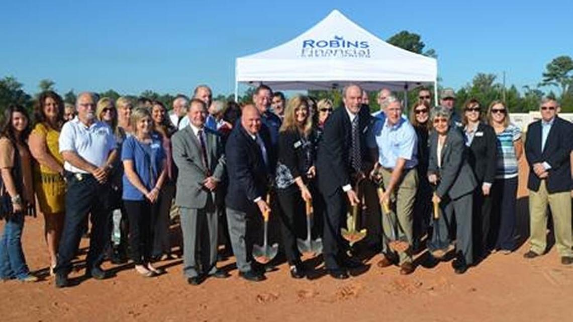 John Rhea, president and CEO of Robins Financial Credit Union (center, in suit) along with senior management staff join members of the Dublin-Laurens County Chamber of Commerce Oct. 13, 2016 for the ceremonial groundbreaking of the company’s first branch in Dublin.