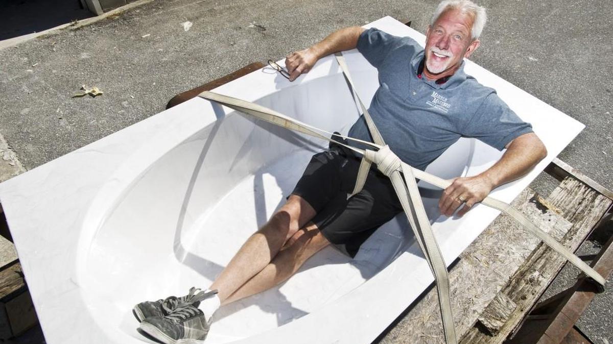 Neil Suggs, co-owner of Marble Masters of Middle Georgia Inc., poses in a new bathtub that is ready to be delivered. The company custom manufactures bath and kitchen counters, bathtubs and more.