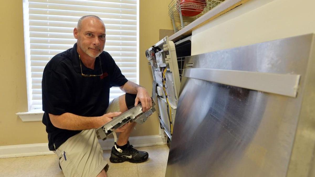 Darrell White, owner of Morris Appliance Repair in Macon, works on a dishwasher Thursday.