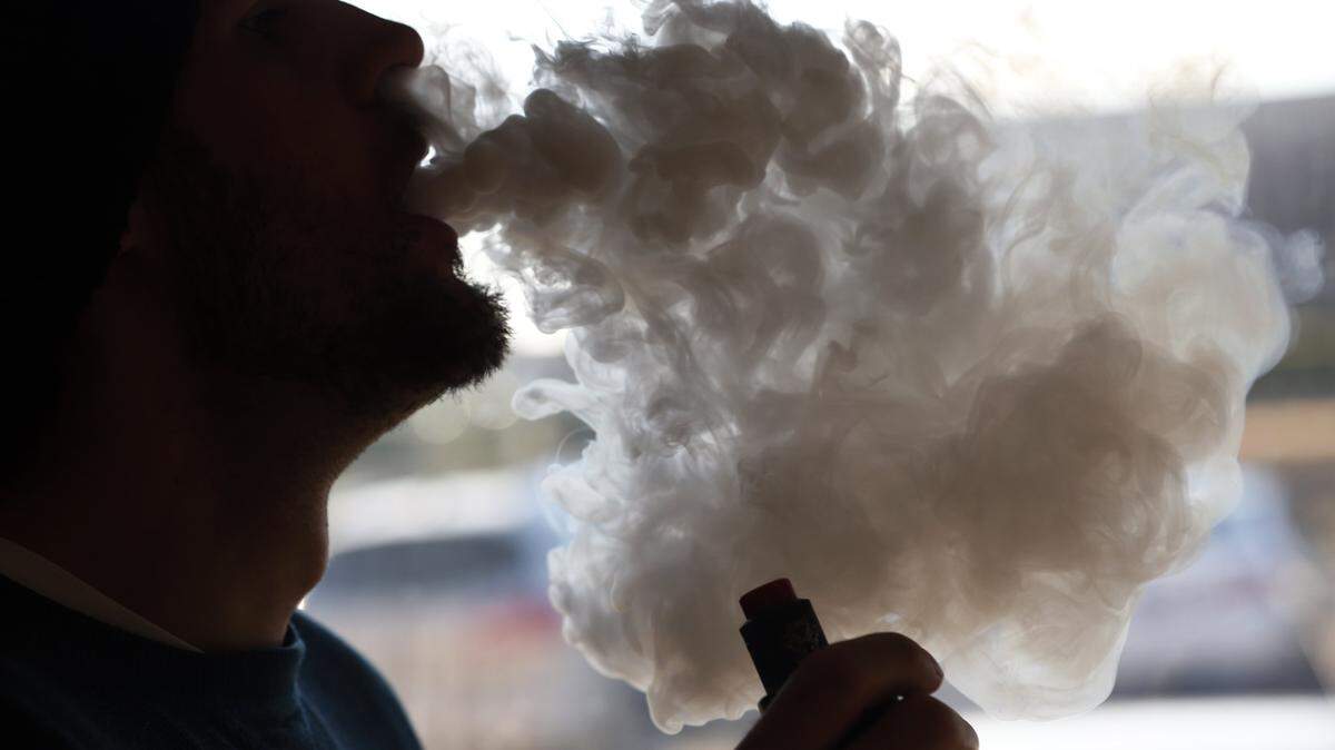 A man using a vape pipe exhales a cloud of smoke at a vape shop in Richmond, Virginia., in January 2019.