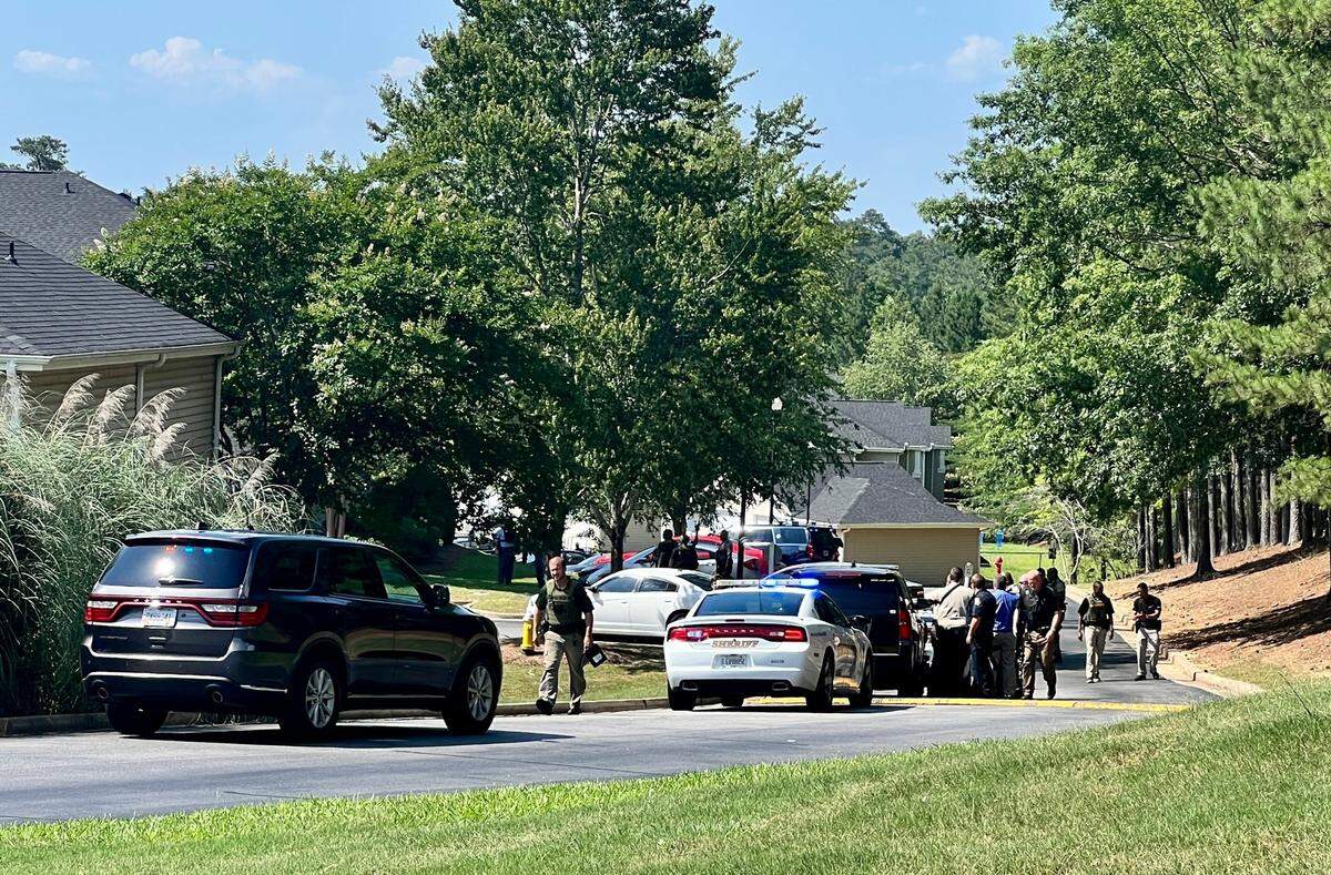 Law enforcement officers search the Hunters Run Apartments off of Thomaston Road during a search for suspects who reportedly fired at Bibb County Sheriff’s deputies.