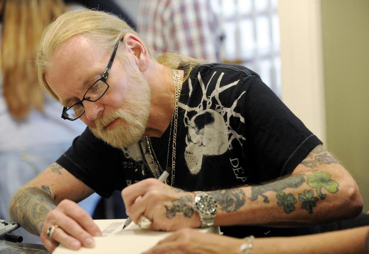 Gregg Allman signing a copy of his memoir.