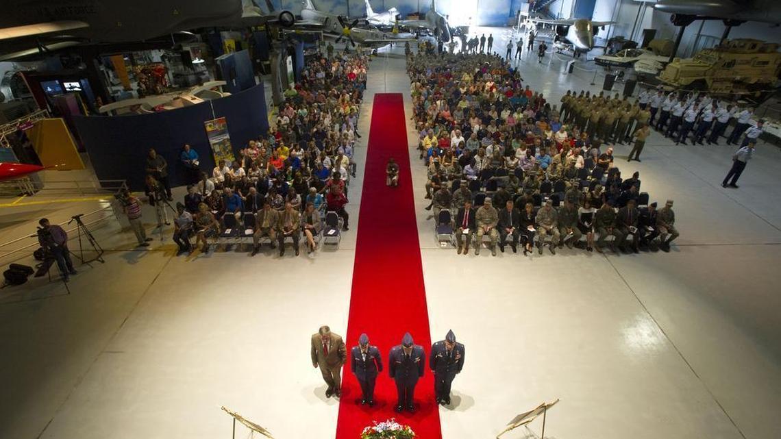 Centerville mayor John Harley, left, Colonel Jeffery King, right, and two airmen pay their respects after laying the memorial wreath at the Camellia Gardens Installation Memorial Service at the Museum of Aviation Thursday.