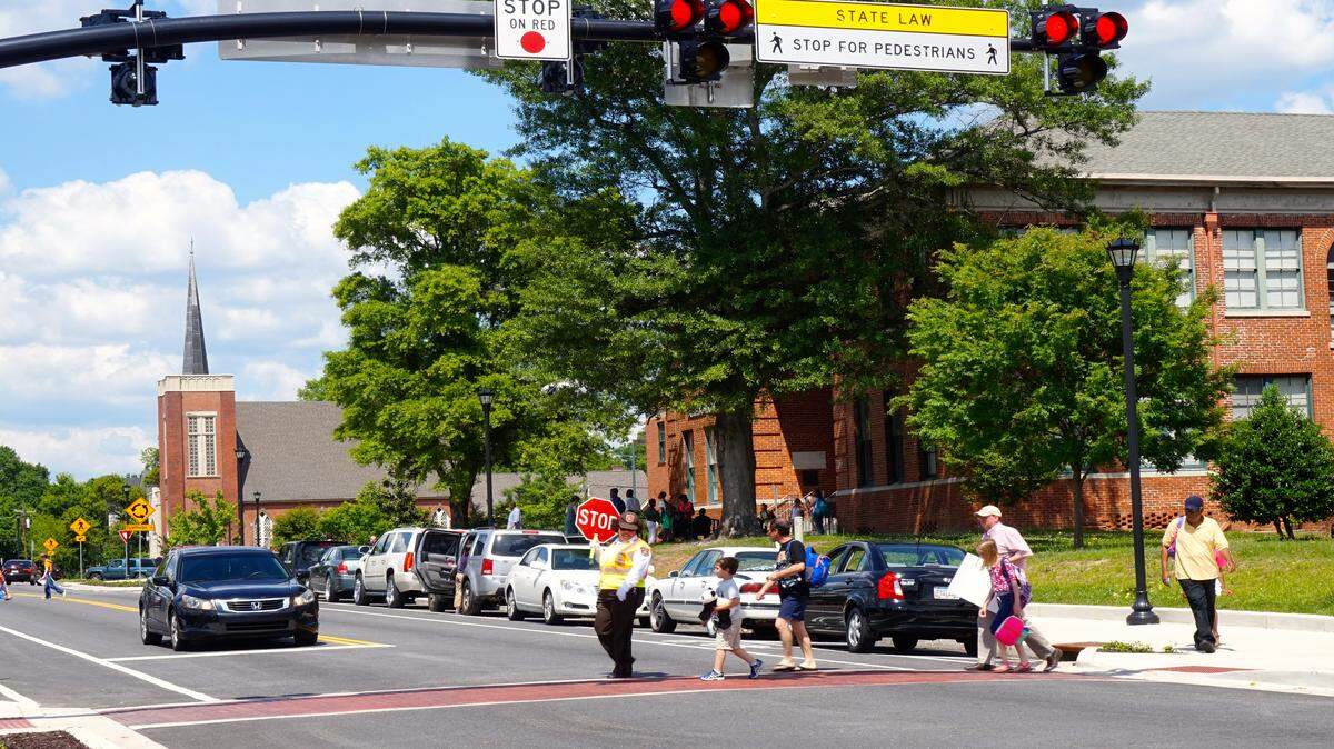 Pedestrians cross in front of Alexander II elementary school on College Street in Macon.