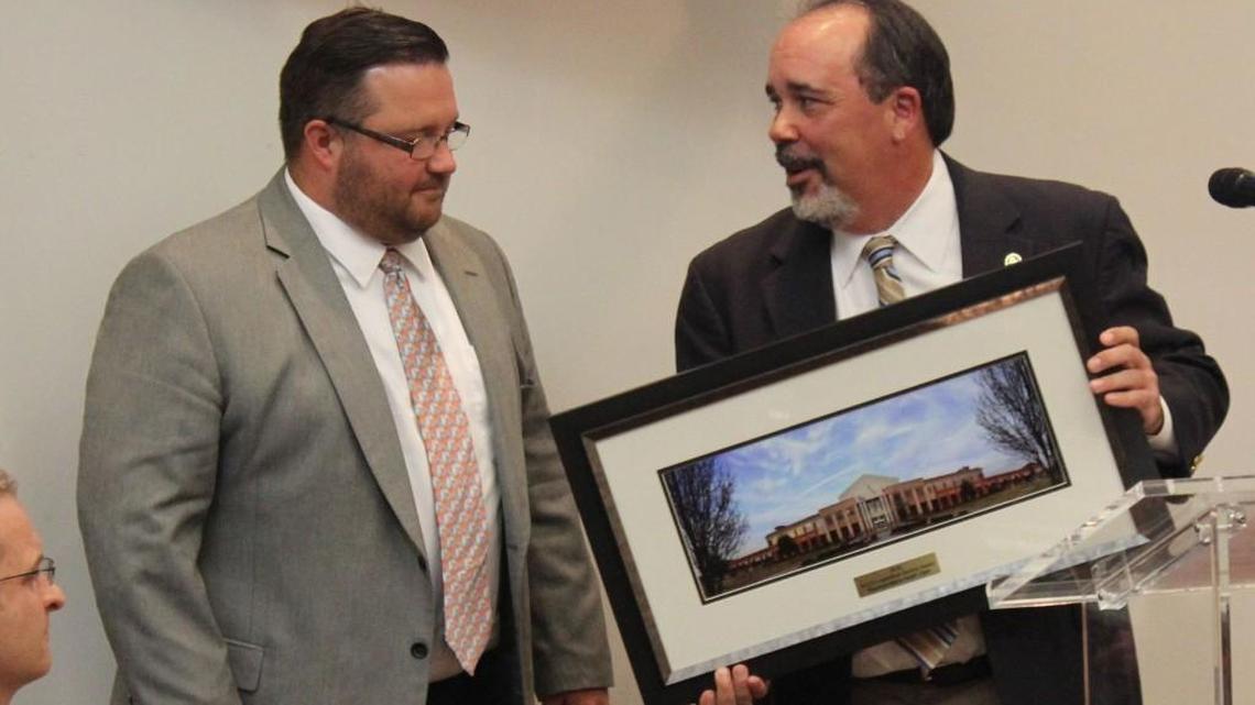 Todd Edwards, right, of the Association County Commissioners of Georgia, presents Houston County State Rep. Heath Clark with a photo of the Houston County courthouse for his efforts to get a bill passed that fixed an issue with early voting.